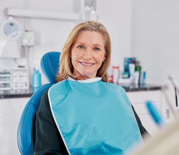 Happy middle-aged patient in dental treatment chair