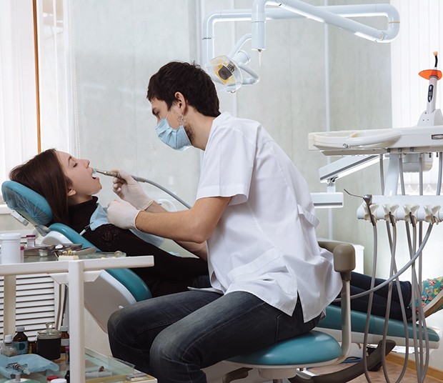 Dentist performing treatment on female patient