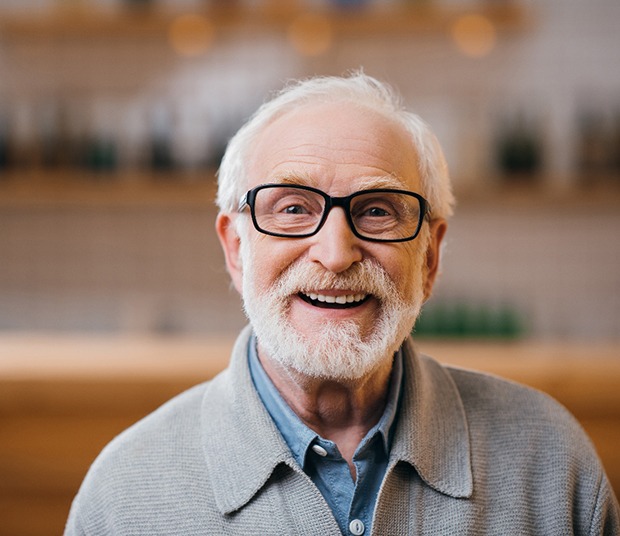 Bearded senior man with glasses smiling