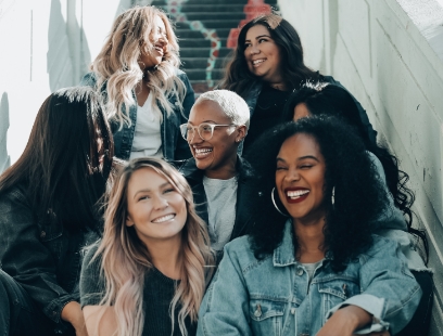 Group of young adults smiling and sitting on staircase