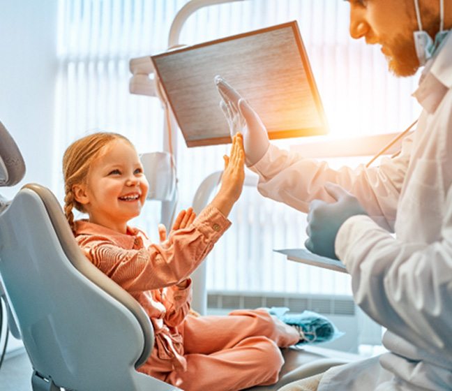 Girl giving a high-five to her dentist 