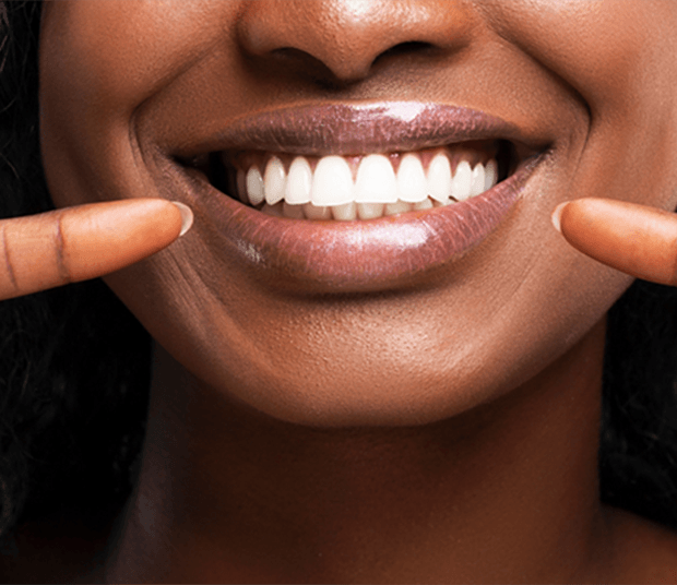 Close up of patient pointing to white teeth