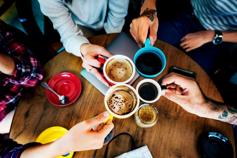 A group of friends with good oral health celebrating National Coffee Day