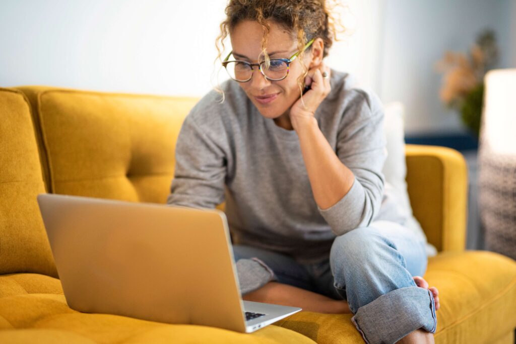 Woman looking at computer on yellow laptop